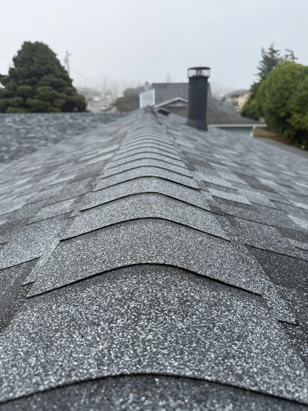 Close view of hip and ridge cap shingles running toward a chimney