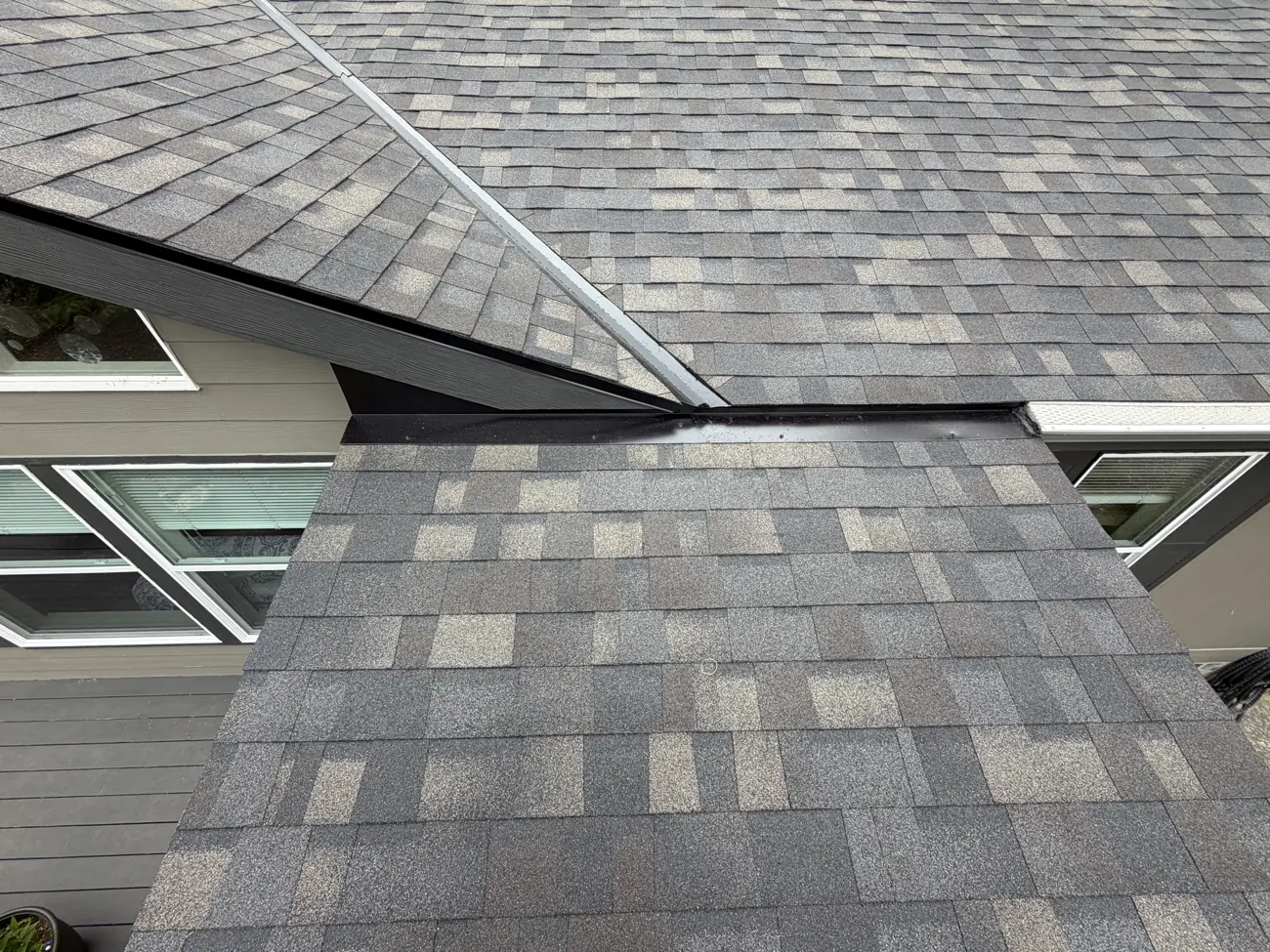 A shingled roof valley meeting a wall with new step flashing